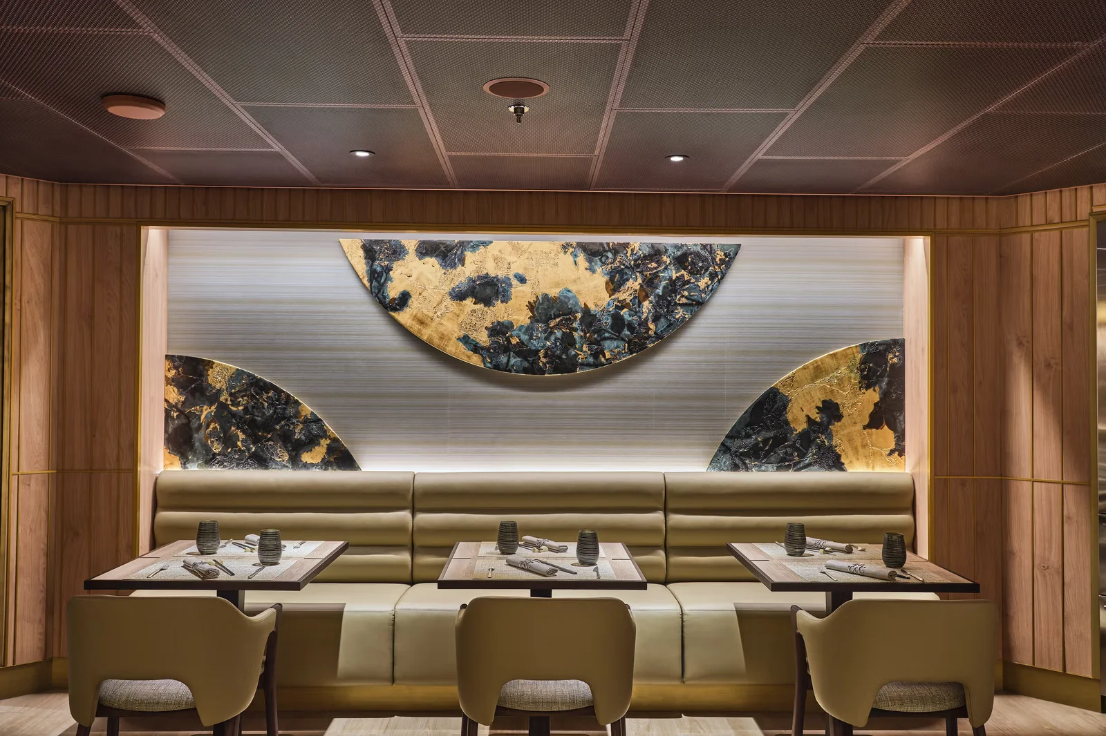 Silversea specialty restaurant with dramatic gold leaf art installation and intimate banquette seating